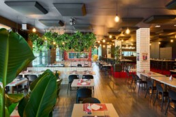 Vista generale della sala della Pizzeria Luna Rossa con pannelli fonoassorbenti a soffitto installati da 2B Resine per migliorare l’acustica del locale.